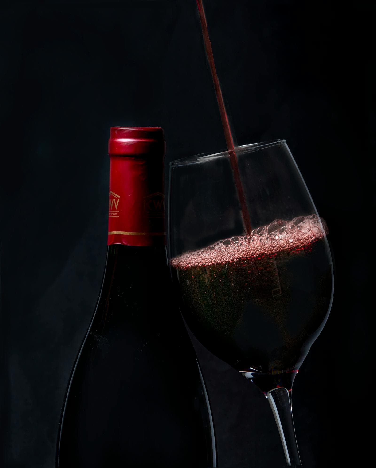 Premium wine bottle being poured into a glass — wine cellar services hero